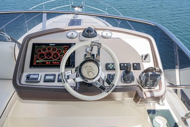 The Riviera Yacht Photos Pics 2017 Monte Carlo MC5S yacht helm with steering wheel, navigation controls, and digital display.