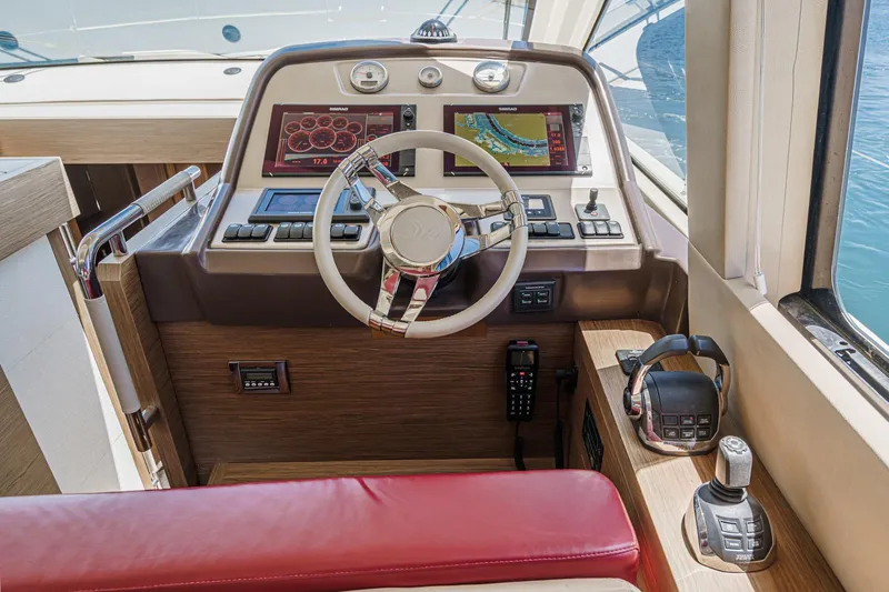 The Riviera Yacht Photos Pics Cockpit of 2017 Monte Carlo MC5S yacht with modern navigation controls and red seating.