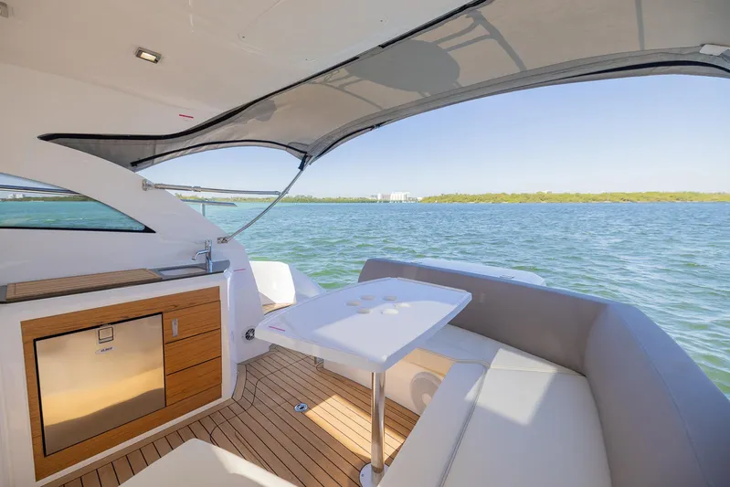  Yacht Photos Pics 2024 Sessa Marine C36 OB yacht interior with seating and table, overlooking serene water.