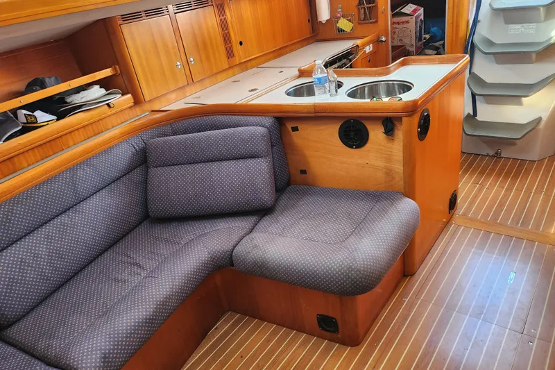 Runaway Yacht Photos Pics Interior of a 2005 Elan 40 yacht with cozy seating and wooden cabinetry.