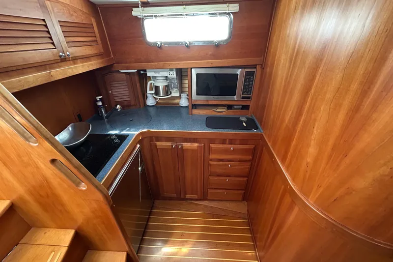  Yacht Photos Pics 2005 Sabre 38 yacht kitchen with wood cabinetry, sink, microwave, and coffee maker.