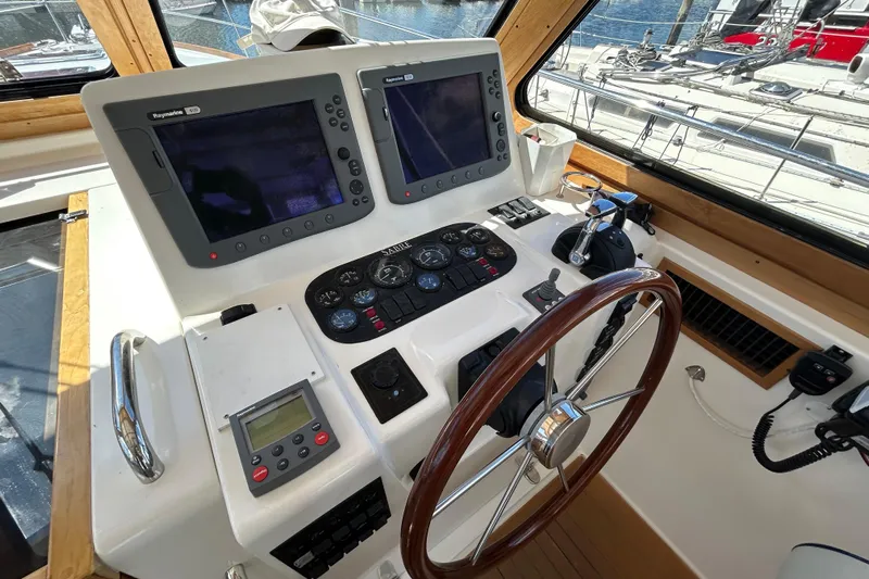  Yacht Photos Pics Helm of 2005 Sabre 38 yacht with navigation equipment and wooden steering wheel.