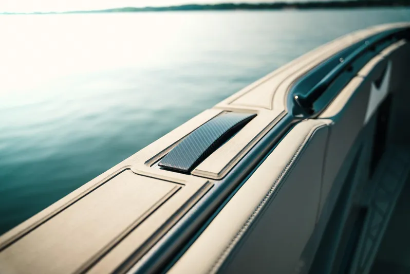  Yacht Photos Pics Close-up of 2026 Deep Impact 499 Sport boat railing with sleek design on calm water.