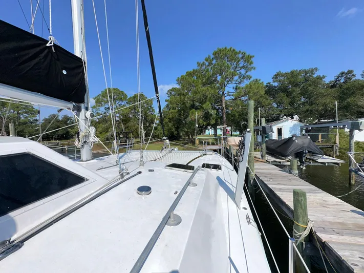 Sola Fide Yacht Photos Pics 1993 Russell Yachts Crowther sailboat docked near trees and waterfront homes.