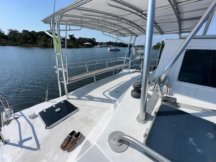 Sola Fide Yacht Photos Pics 1993 Russell Yachts Crowther sailboat deck with canopy, moored on a calm river.