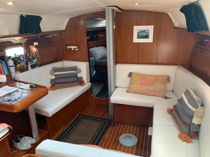  Yacht Photos Pics Interior of 2002 Jeanneau Sun Odyssey 40 sailboat with cozy seating and wooden accents.
