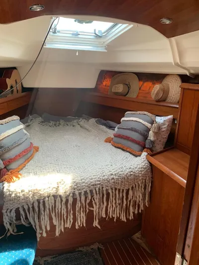  Yacht Photos Pics Cozy cabin interior of 2002 Jeanneau Sun Odyssey 40 with plush bedding and natural light.