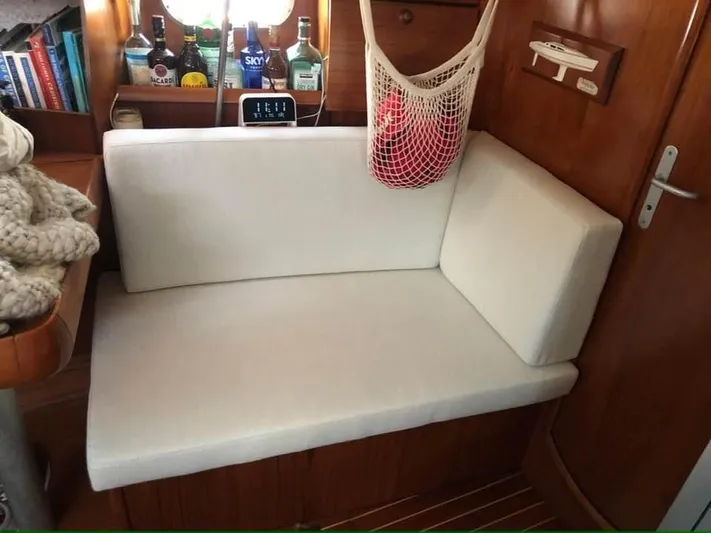  Yacht Photos Pics Cozy interior of 2002 Jeanneau Sun Odyssey 40 sailboat with white cushioned seating.