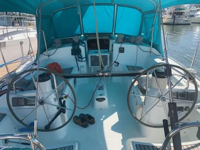  Yacht Photos Pics 2002 Jeanneau Sun Odyssey 40 sailboat cockpit with dual steering wheels and blue canopy.