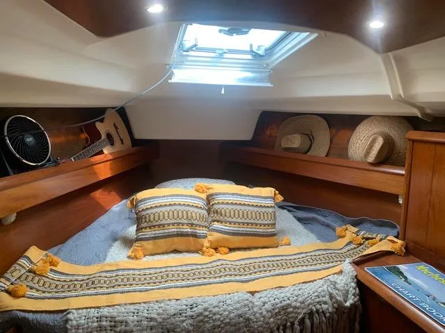  Yacht Photos Pics Cozy cabin interior of 2002 Jeanneau Sun Odyssey 40 with pillows, blankets, and hats.