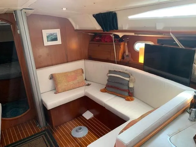  Yacht Photos Pics Interior of 2002 Jeanneau Sun Odyssey 40 yacht with cozy seating and wooden accents.