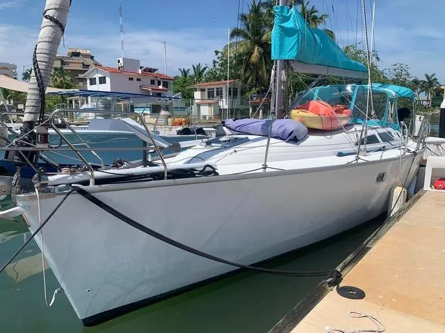  Yacht Photos Pics 2002 Jeanneau Sun Odyssey 40 sailboat docked in a marina, with vibrant blue canopy.