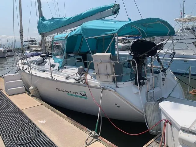  Yacht Photos Pics 2002 Jeanneau Sun Odyssey 40 sailboat docked, featuring turquoise canopy and sail cover.