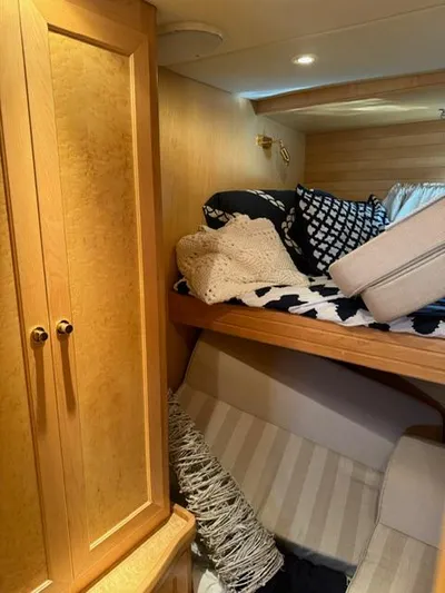  Yacht Photos Pics Cozy cabin interior of 2000 McKinna 57 Pilothouse with wooden cabinetry and bedding.