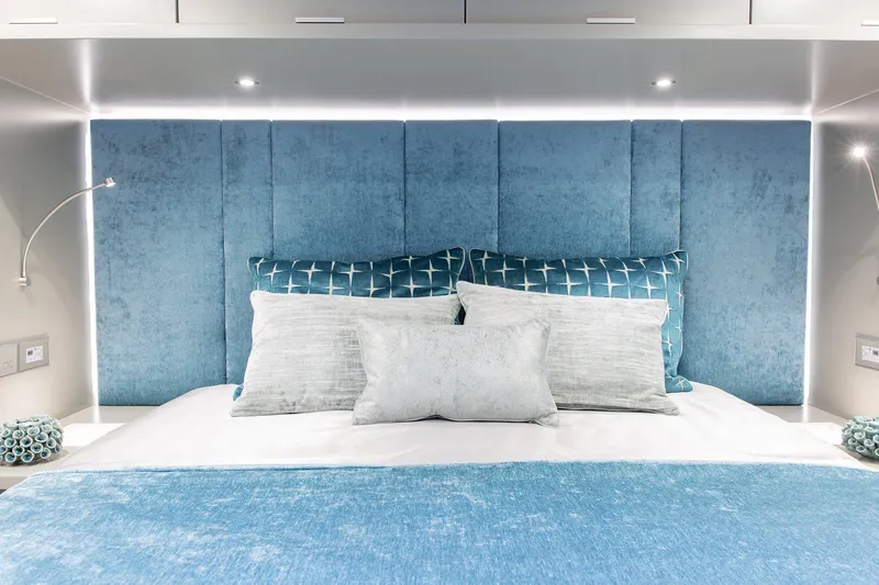  Yacht Photos Pics Luxurious Sunreef 60 yacht bedroom with blue accents, modern lighting, and plush bedding, 2026 model.