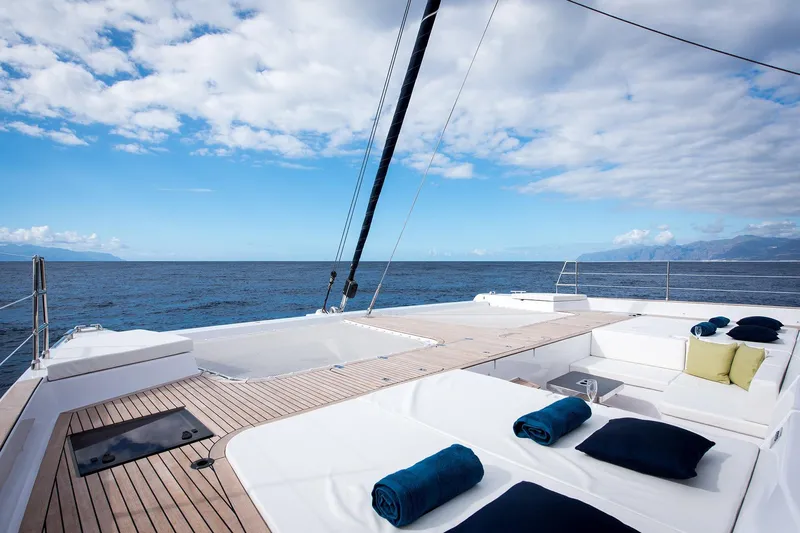  Yacht Photos Pics Luxurious Sunreef 60 yacht deck with ocean view, 2026 model, featuring elegant seating and cushions.