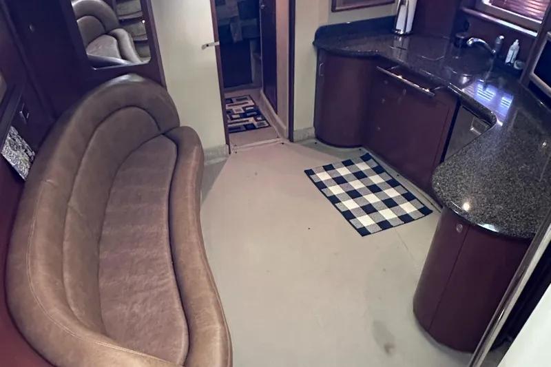 Crash Money Yacht Photos Pics Interior of 2007 Sea Ray 44 Sundancer yacht with curved sofa and kitchenette.