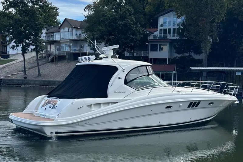 Crash Money Yacht Photos Pics 2007 Sea Ray 44 Sundancer yacht on a calm lake near waterfront homes.