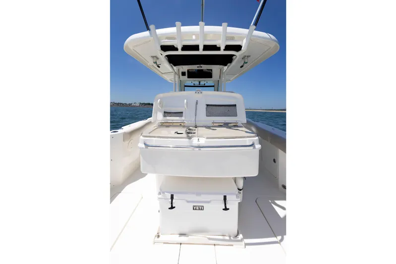 Murphy's Law Yacht Photos Pics 2016 Boston Whaler 330 Outrage boat interior with Yeti cooler, under clear blue sky.
