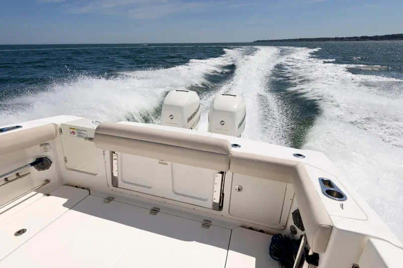 Murphy's Law Yacht Photos Pics 2016 Boston Whaler 330 Outrage cruising on open water, rear view with twin engines.