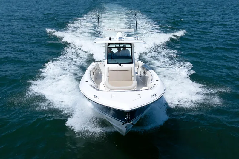 Murphy's Law Yacht Photos Pics 2016 Boston Whaler 330 Outrage cruising on open water, creating a dynamic wake.