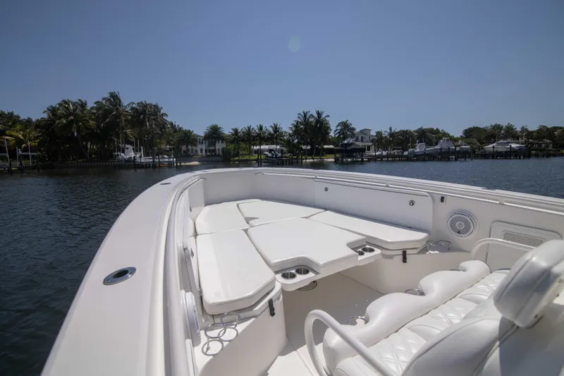 Outta Hand Yacht Photos Pics Everglades 350CC 2009 boat with spacious seating on calm water, surrounded by trees.