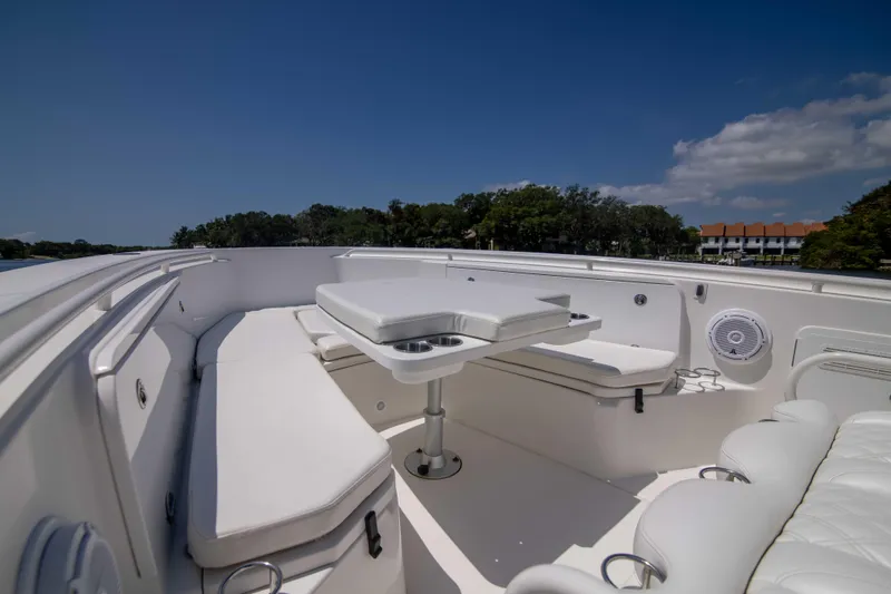 Outta Hand Yacht Photos Pics 2009 Everglades 350CC boat interior with white seating and table under clear blue sky.