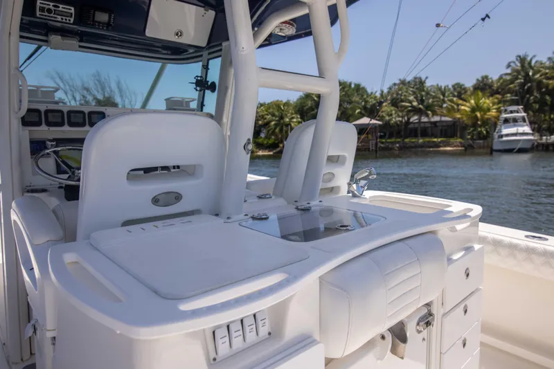 Outta Hand Yacht Photos Pics 2009 Everglades 350CC boat interior with helm and seating, docked by a scenic waterfront.