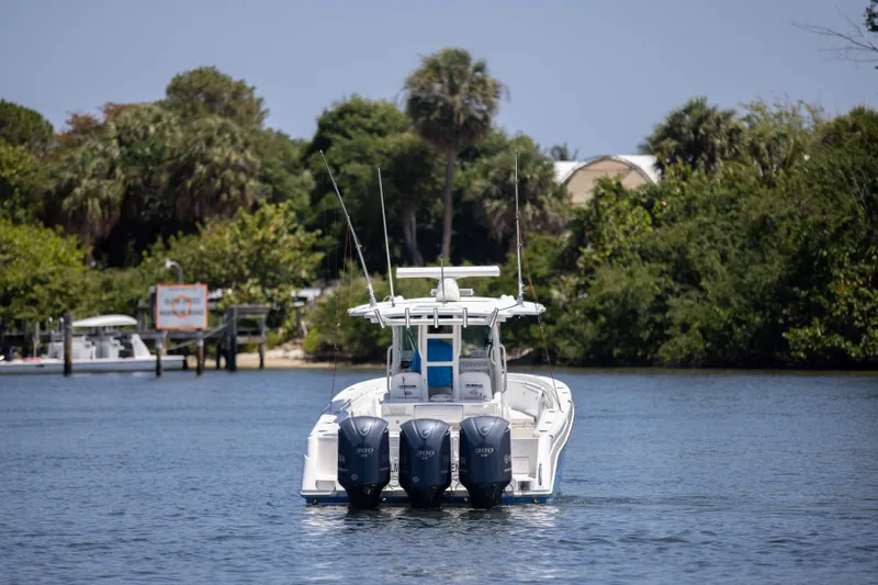 Outta Hand Yacht Photos Pics Everglades 350CC 2009 boat with triple engines on a serene waterway.