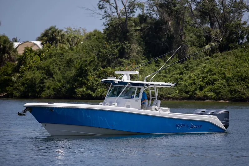 Outta Hand Yacht Photos Pics 2009 Everglades 350CC boat on calm water, surrounded by lush greenery.