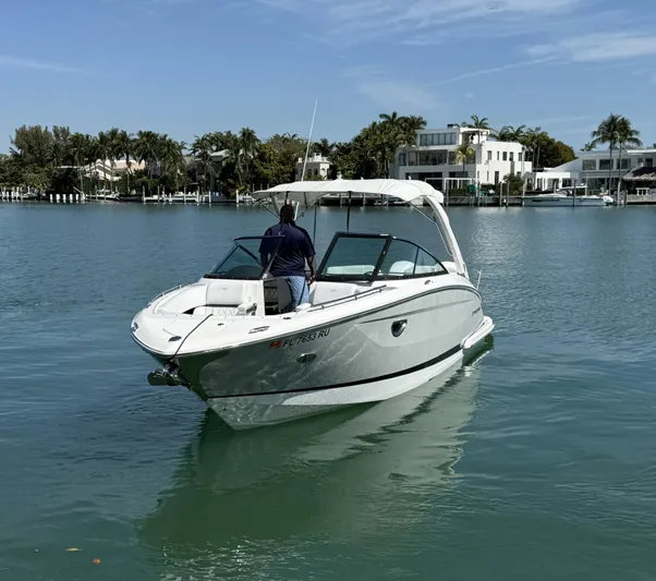  Yacht Photos Pics 2019 Regal 29 OBX boat cruising on calm waters near luxury waterfront homes.