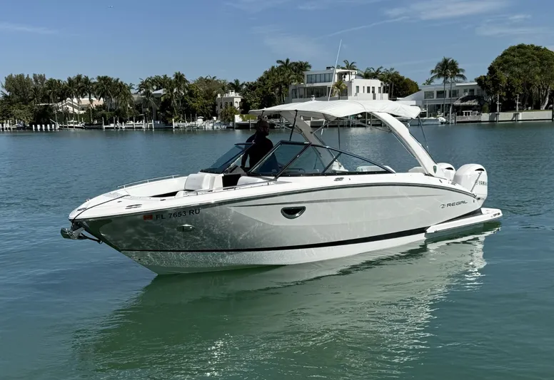  Yacht Photos Pics 2019 Regal 29 OBX boat on calm water, surrounded by waterfront homes.