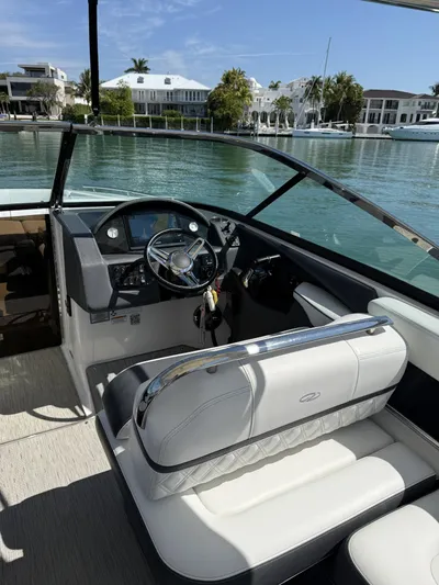  Yacht Photos Pics 2019 Regal 29 OBX boat interior with steering wheel, white seating, and waterfront view.