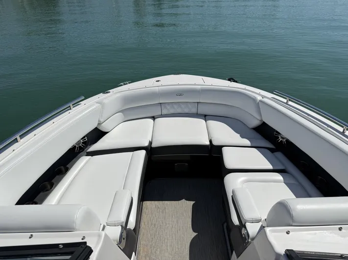  Yacht Photos Pics 2019 Regal 29 OBX boat with spacious white seating, docked on calm water.