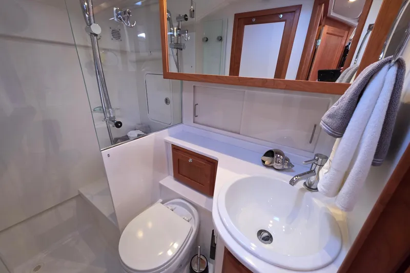  Yacht Photos Pics 2022 Back Cove 372 yacht bathroom with shower, sink, and wooden cabinetry.