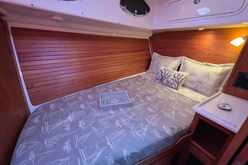  Yacht Photos Pics 2022 Back Cove 372 cabin interior with wooden paneling and nautical-themed bedding.
