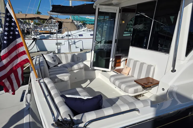  Yacht Photos Pics 2022 Back Cove 372 yacht with striped seating and American flag in marina.