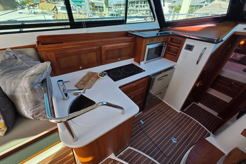  Yacht Photos Pics 2022 Back Cove 372 yacht interior with modern kitchen and wooden cabinetry.