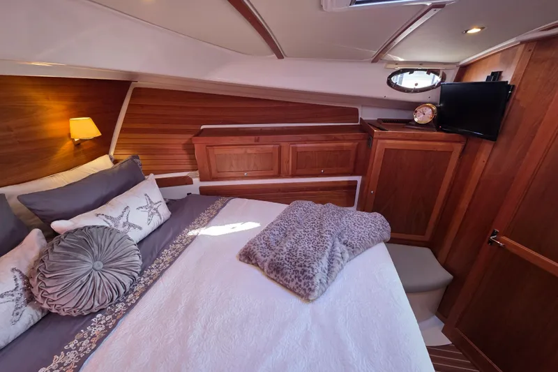  Yacht Photos Pics Luxurious cabin interior of 2022 Back Cove 372 yacht with cozy bedding and wooden accents.