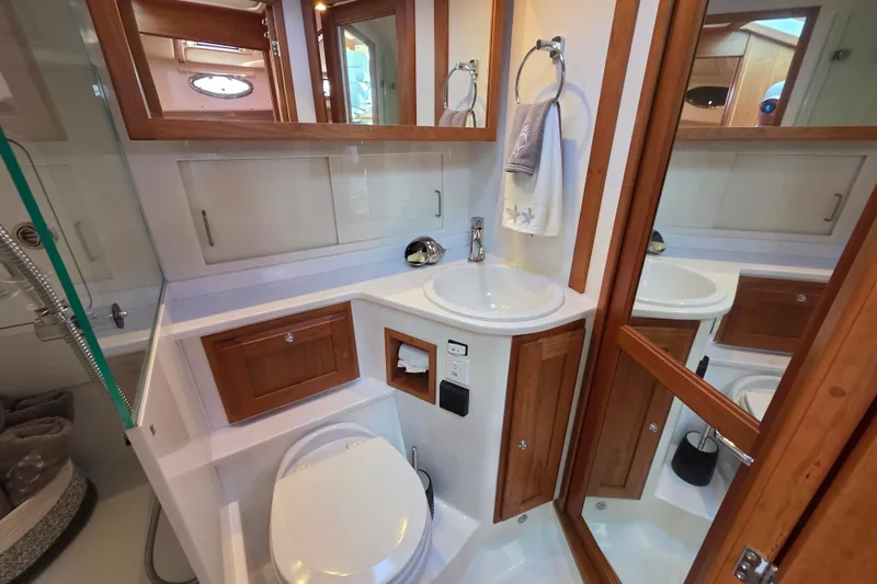  Yacht Photos Pics 2022 Back Cove 372 yacht bathroom with wooden cabinetry and modern fixtures.