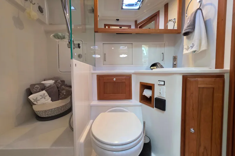  Yacht Photos Pics 2022 Back Cove 372 yacht bathroom with modern fixtures and wooden cabinetry.