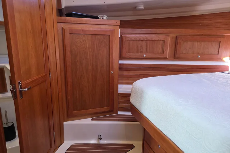  Yacht Photos Pics Luxurious 2022 Back Cove 372 yacht interior with wooden cabinetry and cozy bedding.