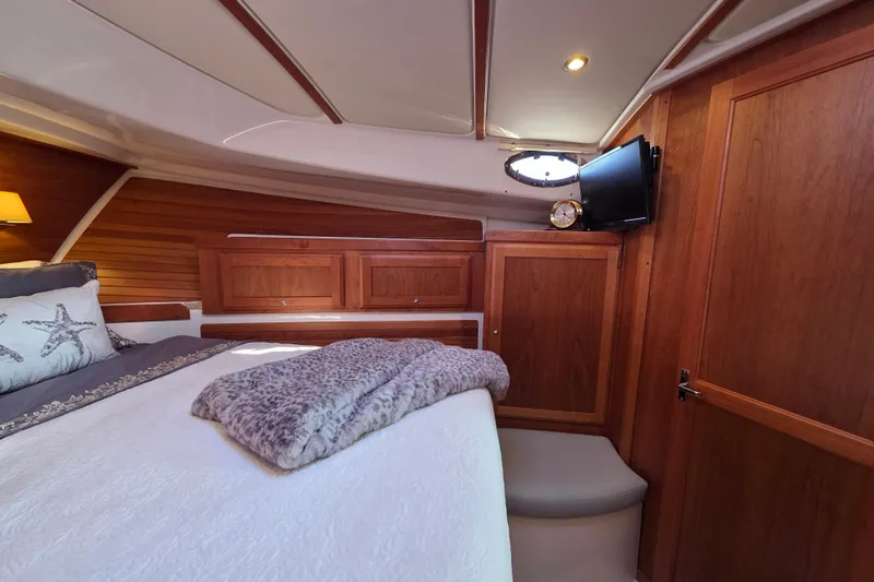  Yacht Photos Pics Luxurious cabin interior of 2022 Back Cove 372 yacht with cozy bedding and wooden finishes.