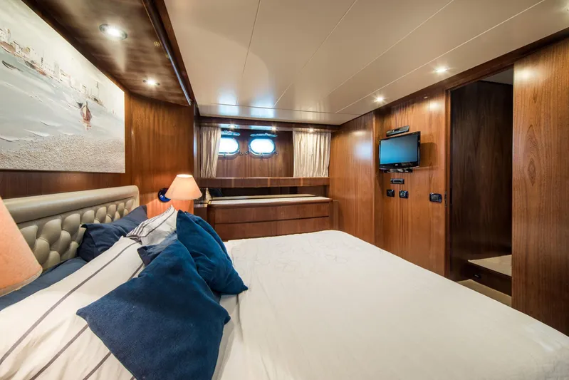  Yacht Photos Pics Luxurious cabin interior of 1998 Sanlorenzo SL72 yacht with wood paneling and cozy bedding.