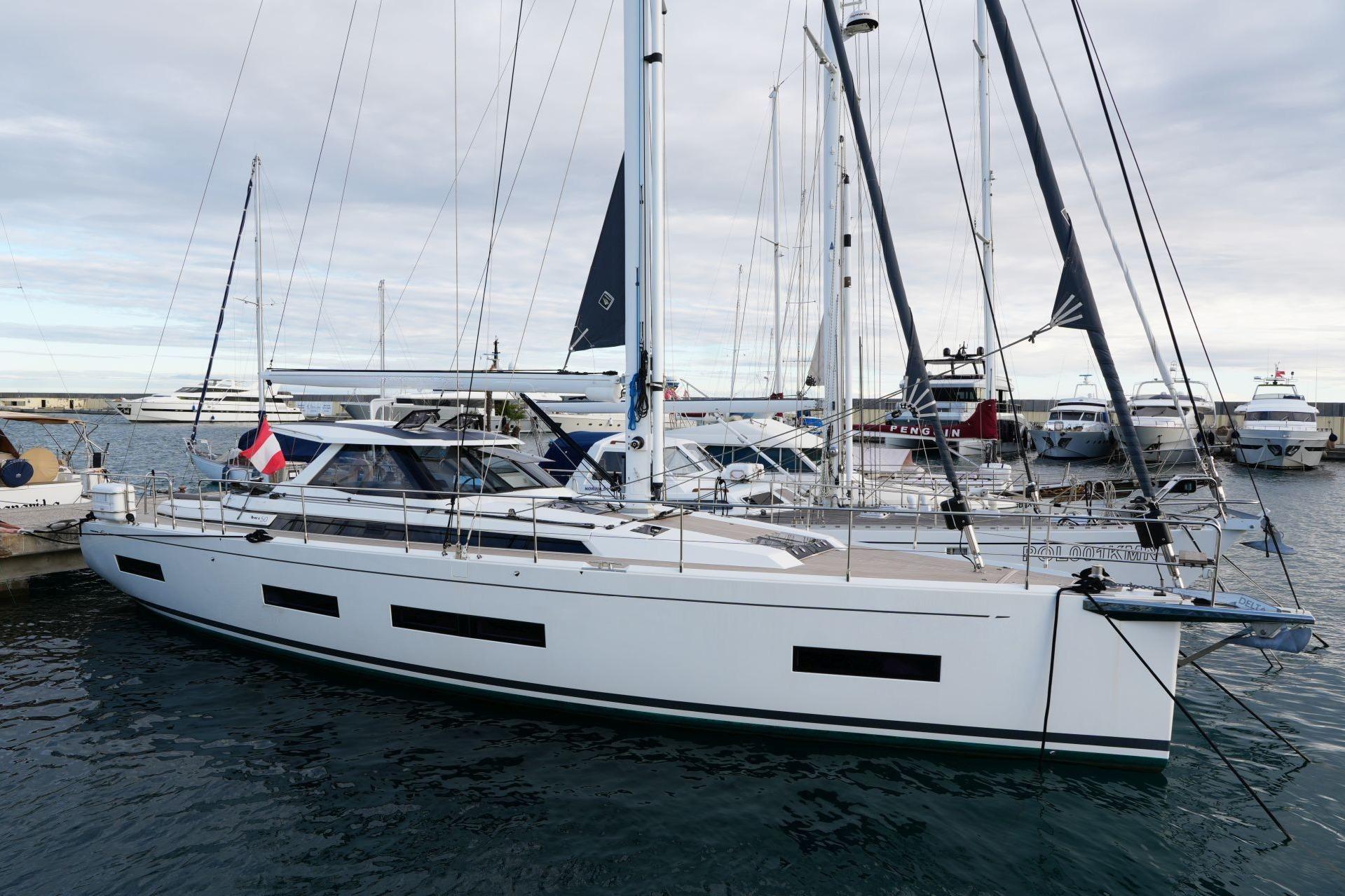 2023 Amel 50 yacht docked at marina, featuring sleek design and modern sails.