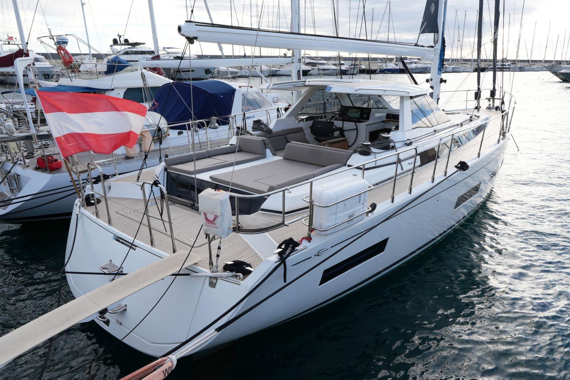 Modern 2023 Amel 50 yacht docked in marina, featuring sleek design and spacious deck.