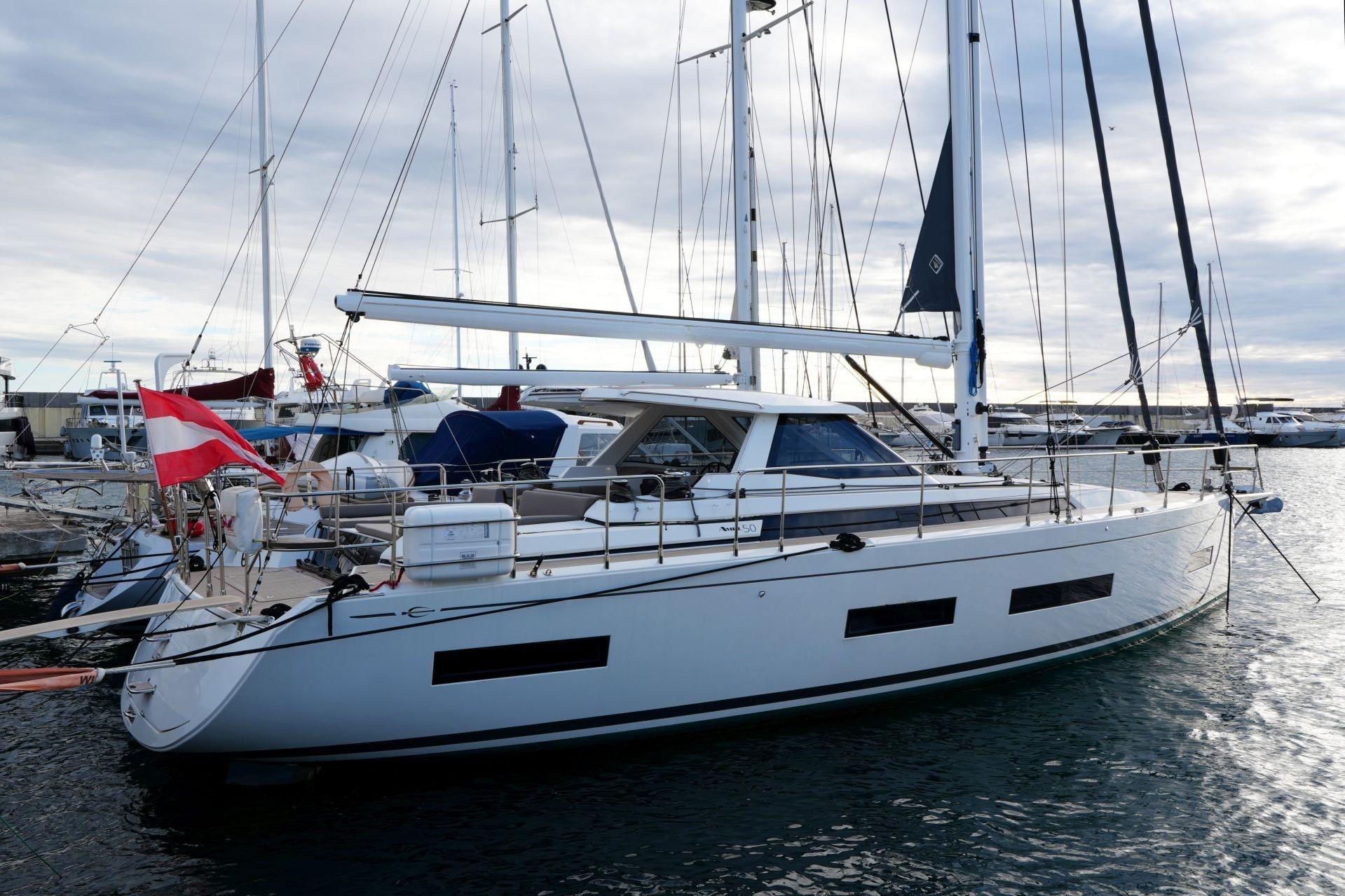 2023 Amel 50 yacht docked at marina, featuring sleek design and modern sails.