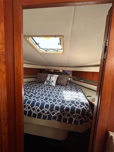 Yacht Photos Pics 1997 Tiara Yachts 4000 Express cabin with nautical-themed bedding and overhead hatch.