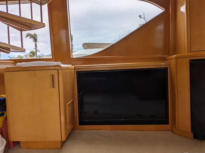  Yacht Photos Pics Interior of a 2001 Hatteras 70 Convertible yacht with wooden cabinetry and a flat-screen TV.