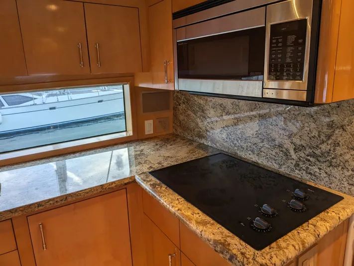  Yacht Photos Pics Modern kitchen in 2001 Hatteras 70 Convertible yacht with granite countertops and stovetop.